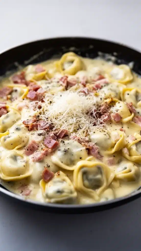 Delicious creamy tortellini carbonara dish garnished with herbs